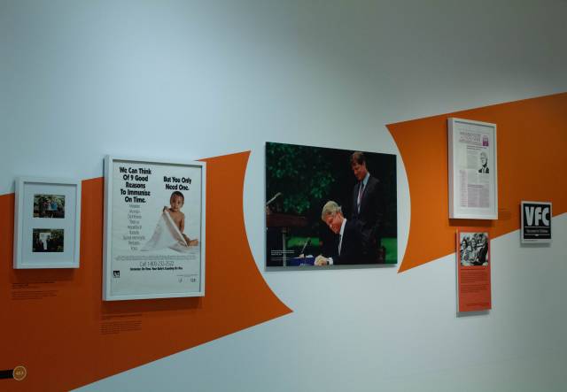 A wall of art with an orange background