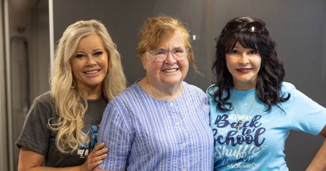 Three women smile for the camera.